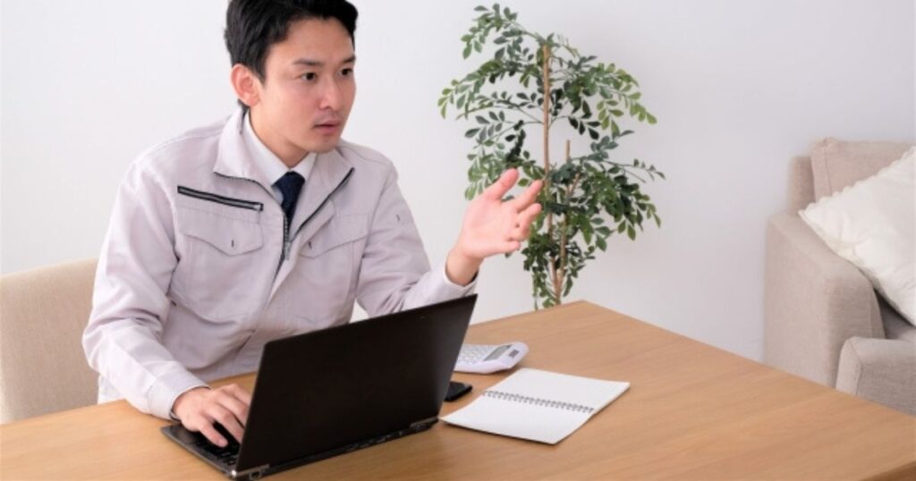説明する作業着の人